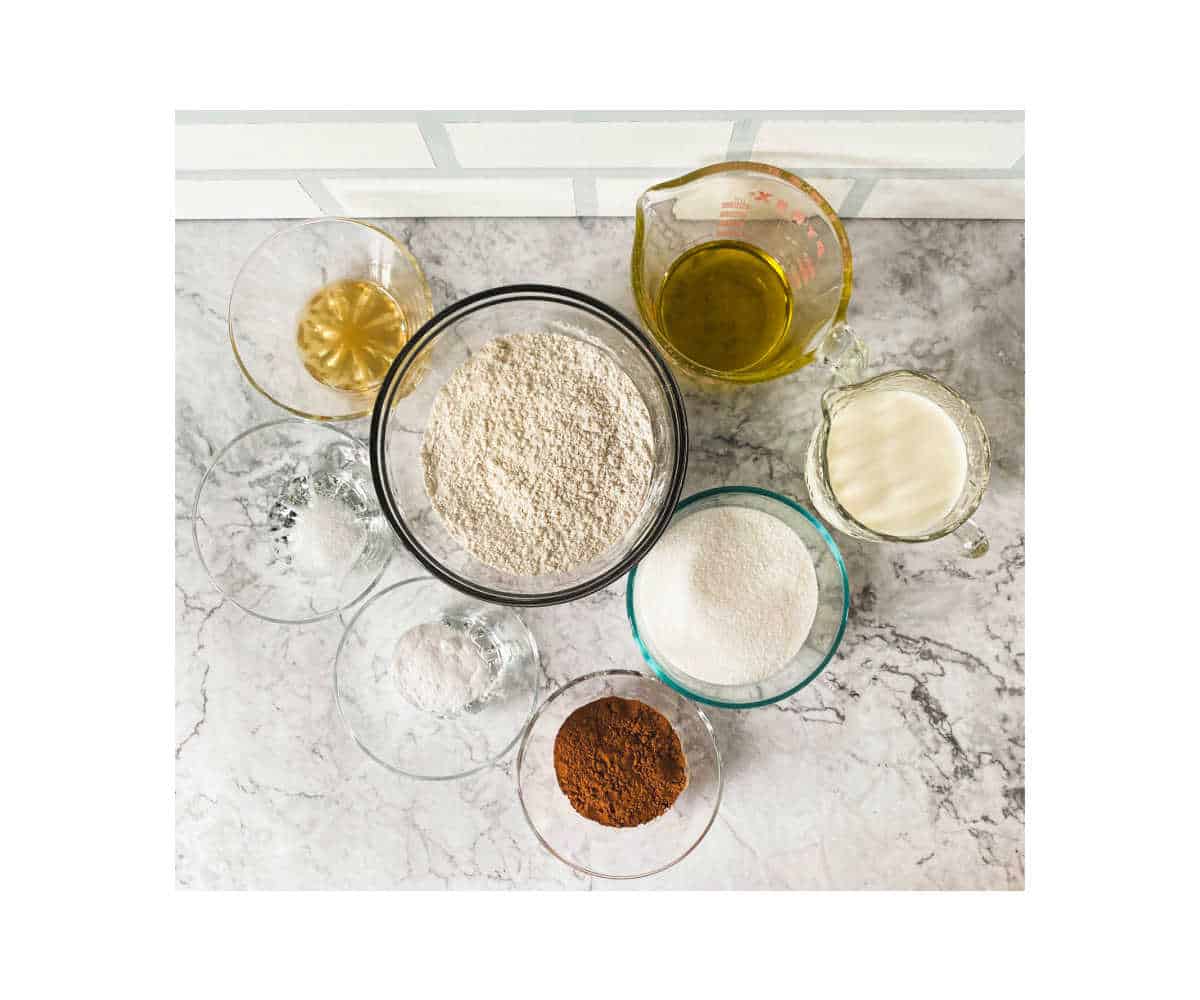 Glass bowls full of baking ingredients for chocolate dairy-free cupcakes.
