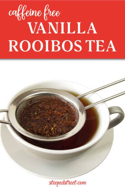 A white teacup and saucer containing vanilla rooibos tea with rooibos tea leaves in a strainer on a white background. The text reads caffeine-free vanilla rooibos tea . steepedstreet.com