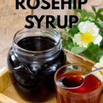 Rosehip syrup in a jar and glass on a wooden tray. The text reads versatile rosehip syrup.