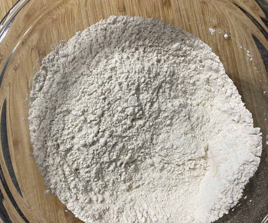 A glass bowl containing flour.