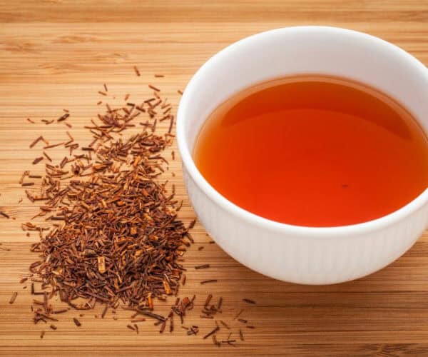 Rooibos tea in a white cup with dried Rooibos.