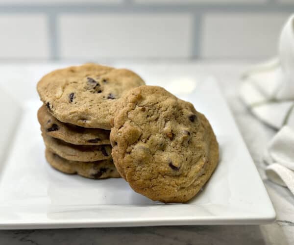 Chocolate chip cookies stacked on a plate.