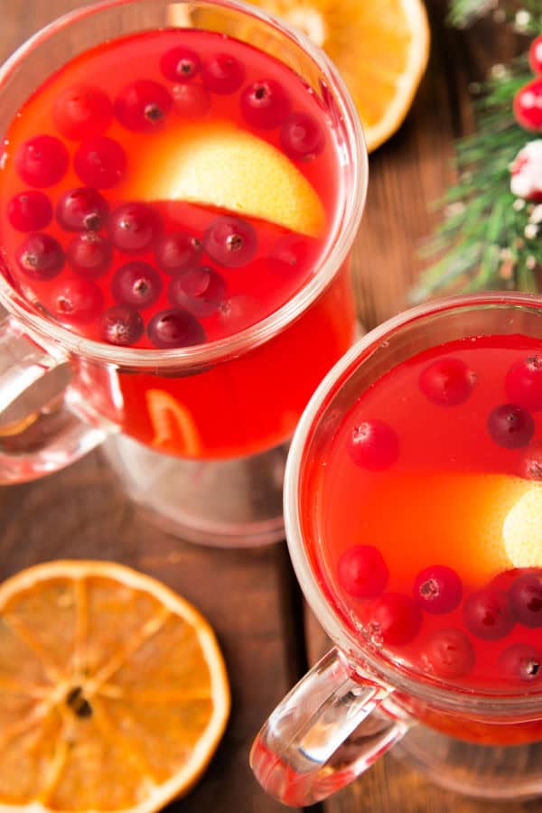 Fresh cranberry orange punch with lemon slices, perfect for holiday brewing and cozy winter mornings, displayed on wooden background.