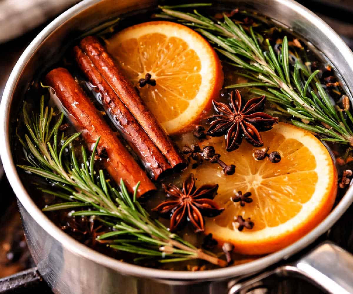 Orange slices, cinnamon sticks, rosemary, and star anise in a simmer pot.