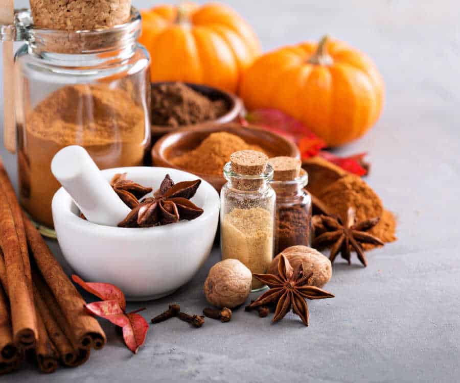 Fall spices and pumpkins on a table.